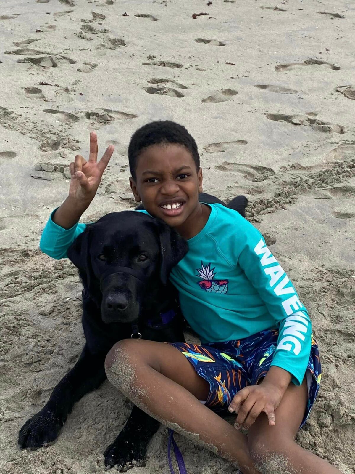 young boy hugging dog